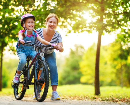 Mom teaches her daughter how to ride a bike while living allergy-free