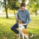 Man Holding Stick in Front of Dog