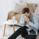 Man sneezing at home in the Philadelphia area next to his allergy medications